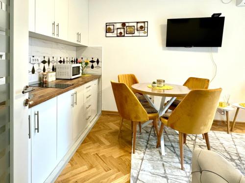 eine Küche und ein Esszimmer mit Tisch und Stühlen in der Unterkunft Apartman KaLux in Vrnjačka Banja