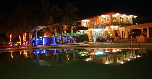 a house with christmas lights in front of a swimming pool at The Byke Old Anchor Beach Resort & Spa in Cavelossim