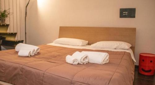 un grande letto con due cuscini e asciugamani sopra di Apollo Theater Palace Lecce Exclusive Terrace a Lecce