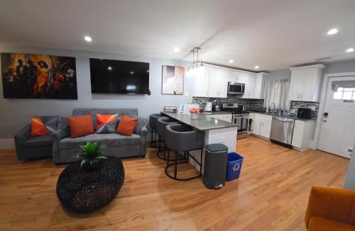 a living room with a couch and a kitchen at Brand New 2BR House 20Min Downtown Boston in Boston