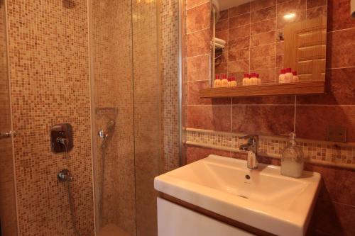 a bathroom with a sink and a shower at Cunda Kivrak Hotel in Ayvalık