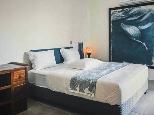 una camera da letto con un letto e un quadro sul muro di Stunning seasides retreat a Bora Bora