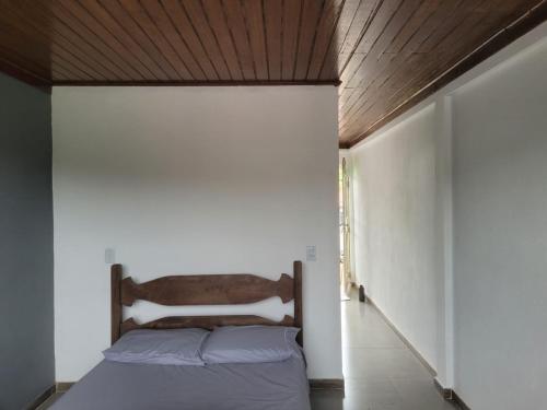a bedroom with a bed and a wooden ceiling at Pousada Cachoeira in Itambé do Mato Dentro