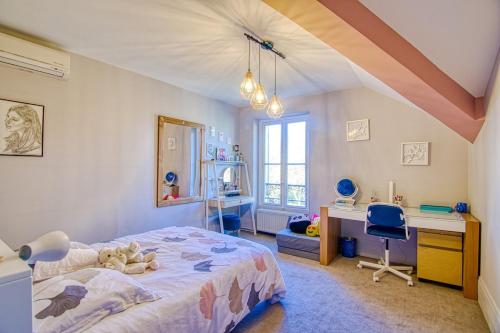 una camera da letto con un letto, una scrivania e una sedia di Somptueuse villa au coeur du parc de la princesse a Le Vésinet