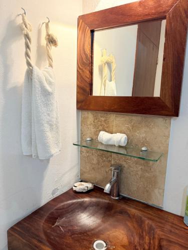 a bathroom with a wooden sink and a mirror at Casa de 3 recámaras en Bacocho in Puerto Escondido
