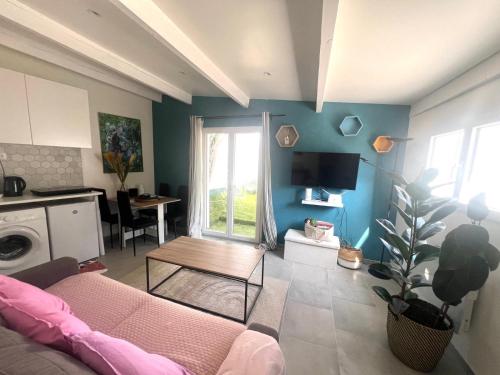a living room with a pink couch and a table at Maison Marseille Jacuzzi, jardin, parking in Marseille