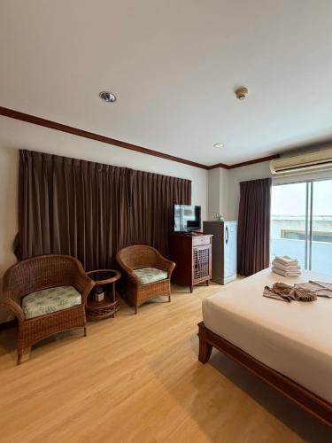 a hotel room with a bed and a television at Inn House- SHA Extra Plus in Pattaya
