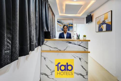 a woman sitting at a reception desk in a room at FabHotel Lorwen in Hyderabad
