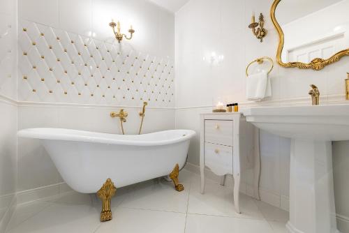 a white bathroom with a tub and a sink at Zamek Rzucewo in Rzucewo
