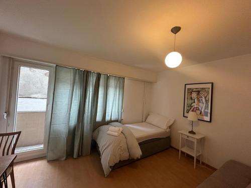 a small bedroom with a bed and a window at Hostel City Basel 389 in Basel