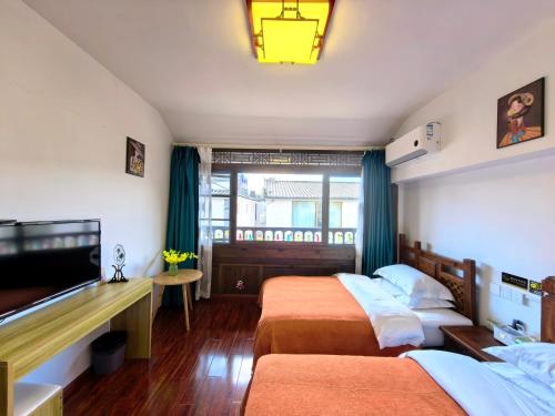 丽江馨舍精品客栈的一间配有两张床和一台平板电视的酒店房间
