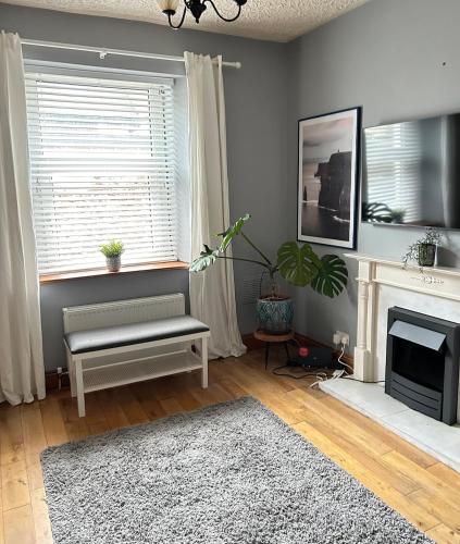 a living room with a bench and a fireplace at Quiet townhouse in Cork in Cork