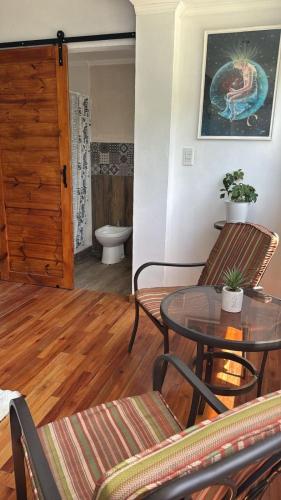 a room with a table and chairs and a bathroom at Margaritas y Soles Petit Hotel in San Miguel del Monte