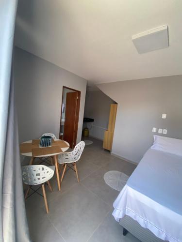 une chambre avec un lit, une table et des chaises dans l'établissement AnaManô Flat térreo, à São Miguel dos Milagres