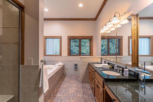 een badkamer met twee wastafels, een bad en een douche bij Amitola at Yonahlossee in Boone