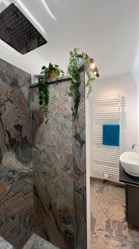 a bathroom with a sink and a stone wall at Ferienhaus Hörnchen in Hellenthal