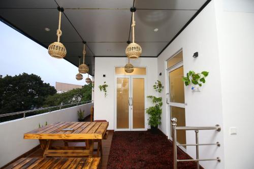 une véranda avec une table en bois et des suspensions lumineuses dans l'établissement Ideal Residence, à Matara