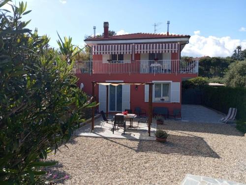 Cette maison rouge dispose d'une table et d'un balcon. dans l'établissement La casa di Giada, appartamento a piano terra in villetta con aria condizionata, wi-fi e parcheggio gratuito, à Poggi