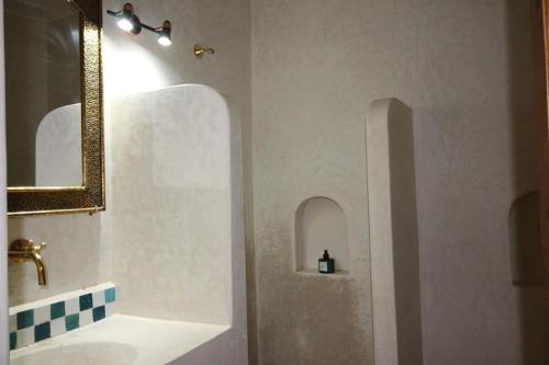 ein Badezimmer mit Waschbecken und Spiegel in der Unterkunft Palais el Abbassia in Marrakesch