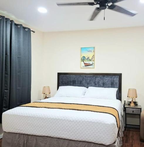 a bedroom with a large bed with a ceiling fan at Rey'z Hotel and Suites in Vreed en Hoop