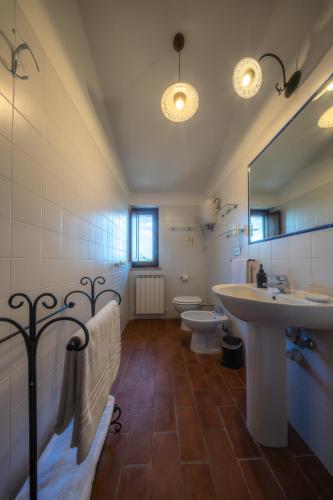 a bathroom with two sinks and a toilet and a mirror at Agriturismo Il Mulino delle canutole in Magione