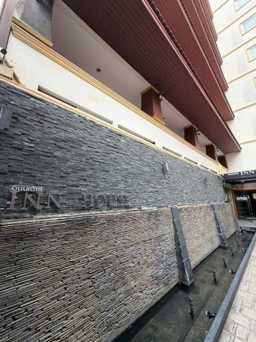 a brick wall with the name of a building at Inn House- SHA Extra Plus in Pattaya