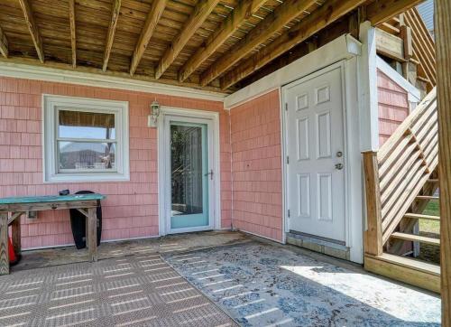 une maison rose avec une porte blanche et une table dans l'établissement Changes In Latitude home, à Holden Beach