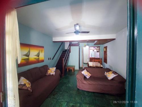 a living room with a couch and a ceiling fan at Triplex na Prainha in Arraial do Cabo