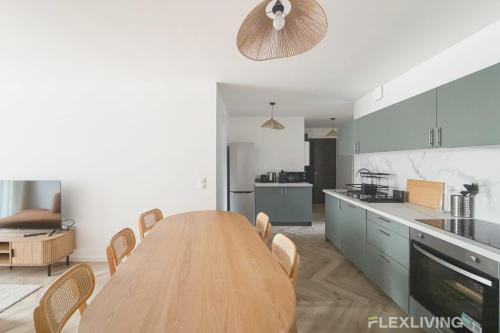 eine große Küche mit Holztisch und Stühlen in der Unterkunft Modern room in spacious T7 in Paris 20 in Paris