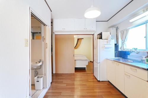 a kitchen with white cabinets and a sink at Tomo House Yoyogi 301 - from 4 minutes station 代々木 301 駅から徒歩4分 in Tokyo