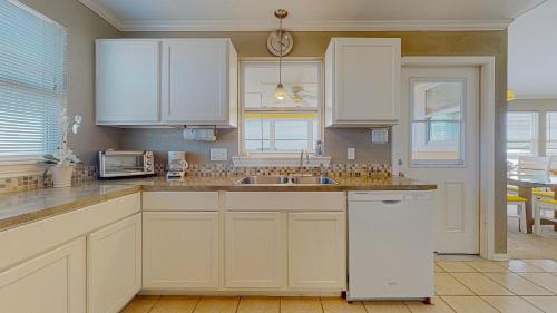 a kitchen with white cabinets and a sink at Sun and Moon in Port Bolivar