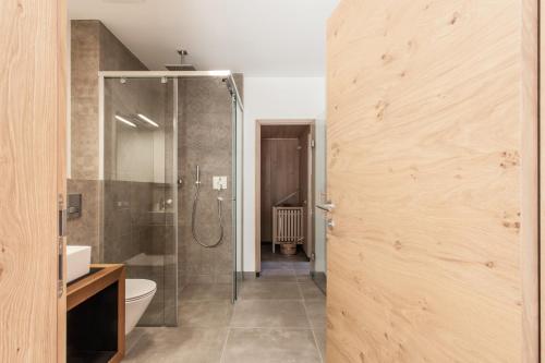 a bathroom with a shower and a glass door at Hubertus Logis Apartments in Brixen im Thale