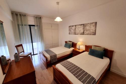 una habitación con dos camas y una mesa y una silla en Abertura Mar Zen, en Cavacos