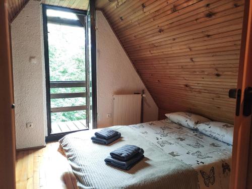 a bedroom with a bed with two towels on it at MALA KUĆA, Lič in Lič