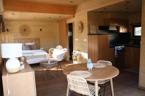 a bedroom with a bed and a table and chairs at Lodge Slow Life - Mas de Rey in Arpaillargues-et-Aureillac