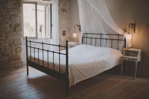 een slaapkamer met een hemelbed en een raam bij Van Gogh - Mas De Rey in Arpaillargues-et-Aureillac