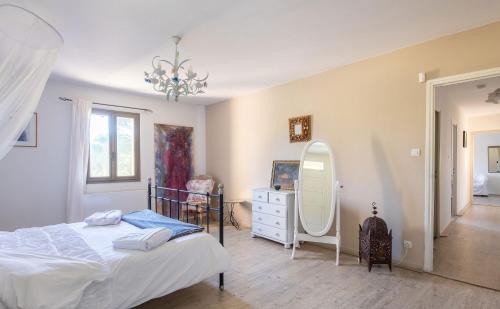 een slaapkamer met een bed, een ladekast en een spiegel bij Rodin - Mas De Rey in Arpaillargues-et-Aureillac
