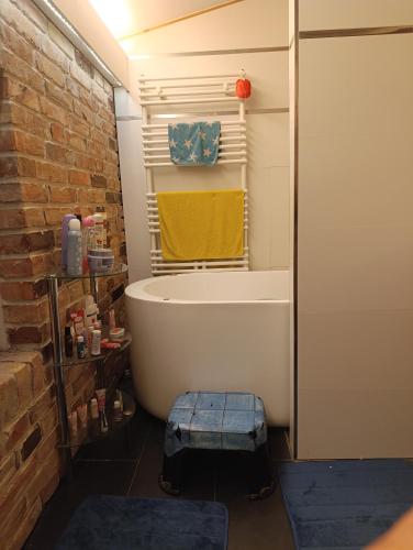 ein Badezimmer mit einer Badewanne und einer Ziegelwand in der Unterkunft Dahai Ferienwohnung Seebad Warnemünde Schulstraße 1, OG in Rostock