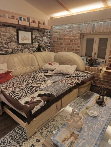 ein großes Bett in einem Zimmer mit Ziegelwand in der Unterkunft Dahai Ferienwohnung Seebad Warnemünde Schulstraße 1, OG in Rostock