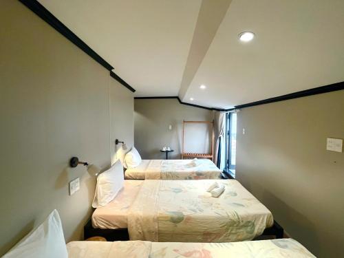 una habitación con tres camas en una habitación en HY Local Budget Hotel - 5 mins walk to Hoi An Ancient Town, en Hoi An