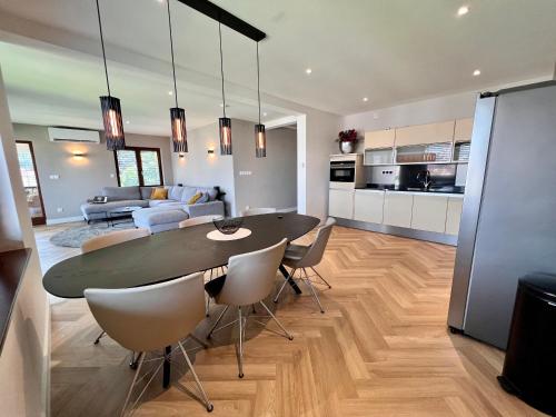 萨拉热窝The Penthouse Sarajevo的一间带桌椅的餐厅和客厅