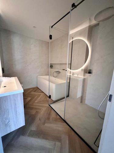a bathroom with a glass shower and a tub and a sink at The Penthouse Sarajevo in Sarajevo