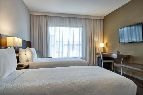 a hotel room with two beds and a window at Intercity Rio de Janeiro Porto Maravilha in Rio de Janeiro