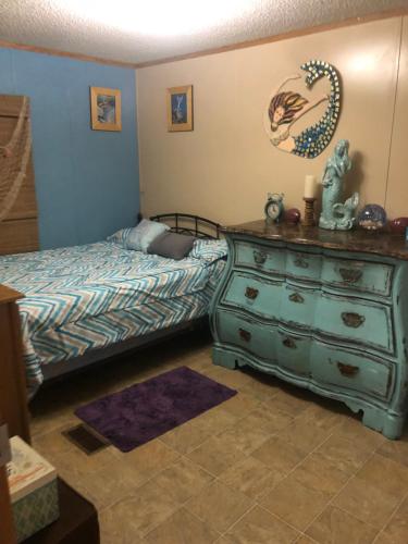 a bedroom with a green dresser and a bed at Rainbow Springs Private 4 acre Country Retreat in Ocala