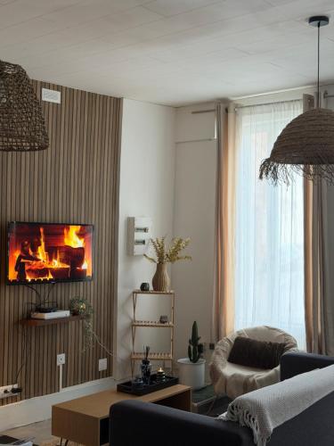 - un salon avec une cheminée au mur dans l'établissement Le clair de lune, à Saint-Amand-les-Eaux