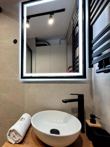 a bathroom with a white sink and a mirror at Apartament Skansen - Sanok in Sanok
