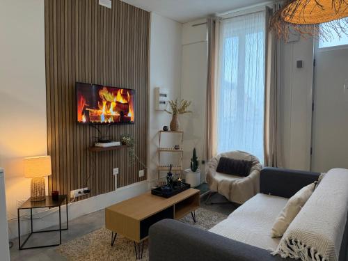 - un salon avec un canapé et une cheminée sur le mur dans l'établissement Le clair de lune, à Saint-Amand-les-Eaux