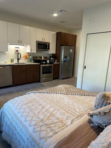 a bedroom with a large bed and a kitchen at Downtown Detroit Studio Apt in Detroit