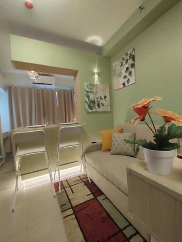 un soggiorno con un divano e due poltrone di R Cabin - Shore Residences a Manila