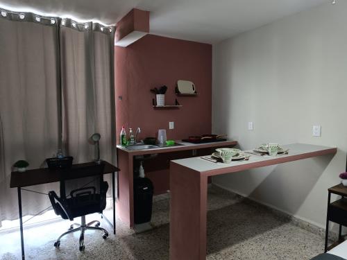 una habitación con dos escritorios y una silla en Suite 105 Cordoba centro y estacionamiento, en Córdoba
